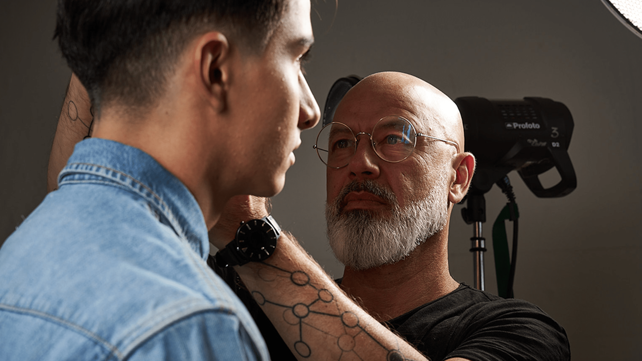 Barber with white beard and black shirt styling hair